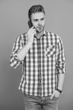 Modern iletişim. Grey 'de izole edilmiş bir adam telefonda konuşuyor. Millennial Man 'e telefon var. Cep telefonuyla konuşan bir adam. Telefon var. Mobil bağlantı. Kulaklıklı adam. Öğrenci yaşam tarzı.