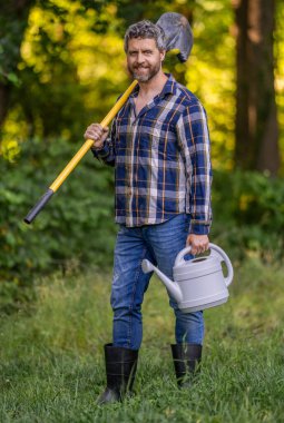 Farmer in spring farm. Man plant a tree with shovel. Work in spring yard with garden tool. Planting and growing plant. Spring farming, springtime. Planting tree. Gardening and farming.
