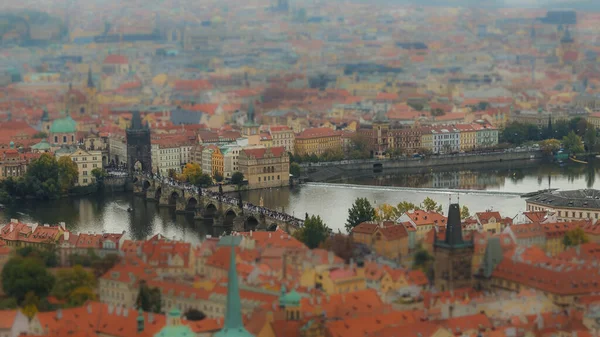 Tilt Shift Photography View of Charles Bridge and Prague Castle. Aerial view of the rooftops of Prague.
