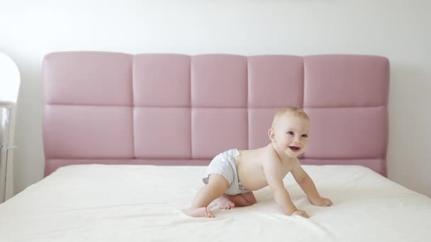 Lindo bebé acostado en la barriga en la cama de los padres, sonriendo pequeño bebé — Vídeos de Stock