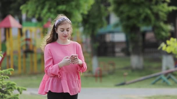 Chica uso de teléfono inteligente al aire libre . Video de stock libre de derechos