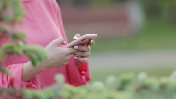 Primer plano de la niña escribiendo un mensaje de texto en el teléfono inteligente o las manos utilizando el teléfono móvil en el parque . Fotografías de stock