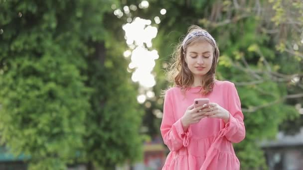 Chica escribiendo mensaje de texto en el teléfono inteligente o las manos utilizando el teléfono móvil en el parque . Imágenes de stock libres de derechos