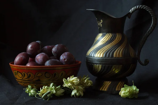 Wooden Bowl Black Plums Vintage Black Gold Jug Some Hops — Stock Photo, Image