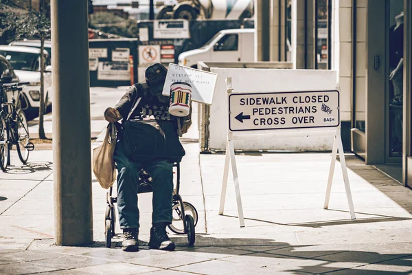 Homeless man is sitting on his wheelchair and asking for help. — Stock Photo, Image