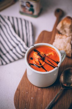 Ev yapımı peynir tortellini ile Sonbahar kırmızı domates kremaçorbası ve balsamik azaltma ile tepesinde. Rustik tarzda çorba kase.