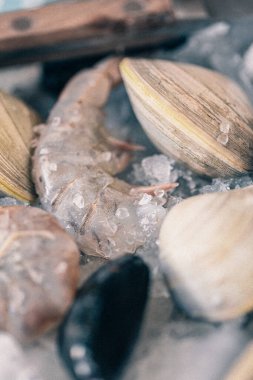 Buz tabaklarında çiğ kabuklu deniz ürünleri. İstiridye, midye, buzlu karides ve taze limon.