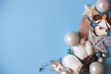 Noel havası düzdü. Yeni yılınız kutlu olsun. Mavi kağıda dizilmiş Noel ağacı süsü. Eldivenler, yıldızlar, geyikler. Ağaç. Eski yılbaşı süslemeleri.