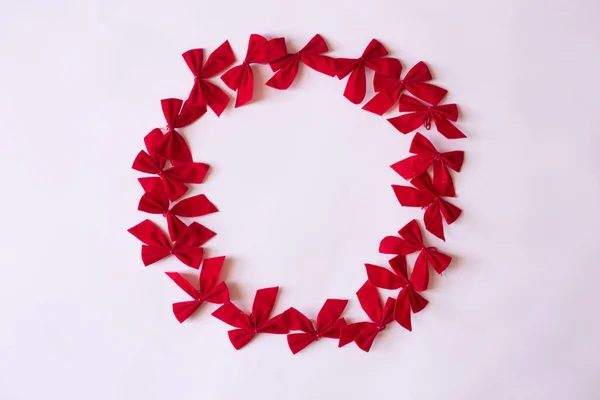 Corda de coroa de arco vermelho em papel branco. clima de Natal deitado plano. Feliz Ano Novo flat lay sobre o papel . — Fotografia de Stock