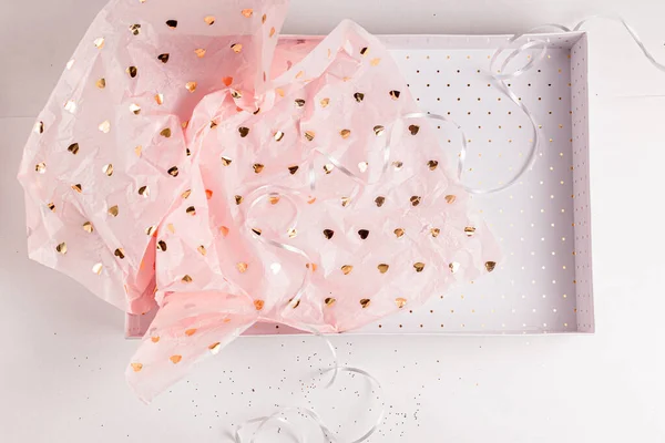 Papier cadeau rose pastel avec cœurs dorés dans une boîte cadeau blanche. Emballage cadeau pour une occasion spéciale. Saint Valentin, fête d'anniversaire, anniversaire de mariage, cadeau de la fête des mères. Cadeau fait main — Photo