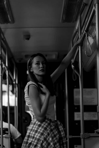 Mujer con el pelo largo en el autobús. Retrato en blanco y negro. Cabalgando en tren. Busco en alguna parte. Traje de moda estilo callejero. Traje de estilo de vida urbano. Camiseta blanca. Chica rebelde. Diferentes emociones . —  Fotos de Stock