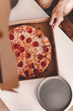 Yemek servisi. Restorandan yemek sipariş etmek. New York tarzı pizza ve film gecesi. Evde aile yemeği. Pepperoni ve peynir sosu. Karton kutu. Cuma partisi. Rahatlatıcı yemek..