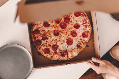 Yemek servisi. Restorandan yemek sipariş etmek. New York tarzı pizza ve film gecesi. Evde aile yemeği. Pepperoni ve peynir sosu. Karton kutu. Cuma partisi. Rahatlatıcı yemek..