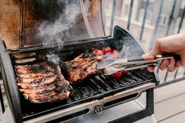 Amerikan usulü barbekü yemeği. Gaz ızgarası. Balkonda tütsülenmiş yemek yapıyorum. Izgara domuz pirzolası. Kırmızı domates. Kömür mantarı. 4 Temmuz 'da. Bağımsızlık Günü yemeği. Aile tatili yemeği. Arka bahçe partisi