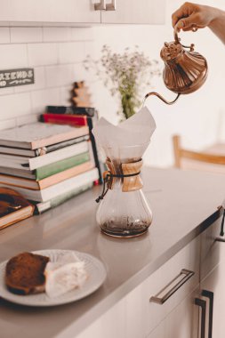 Kocası sabahları taze kahve hazırlıyor da. Yaşam tarzı mutfak tezgahı, masa. Kahvaltı vakti geldi. Yemek hazırlığı. Her gün hoş bir rutin. Bakır çaydanlık. Çalışmaya hazırım. Basit bir hayat.