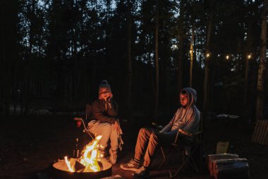 Ormanda kamp ateşi. Ateşin yanında oturuyordum. Rahatla ve rahatla. Ulusal Park Ormanı. İki kampçı tatilde. Yolculuk tatili. Yerel seyahat. Kamp sezonu. 4 Temmuz.