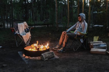 Ormanda kamp ateşi. Ateşin yanında oturuyordum. Rahatla ve rahatla. Ulusal Park Ormanı. İki kampçı tatilde. Yolculuk tatili. Yerel seyahat. Kamp sezonu. 4 Temmuz.