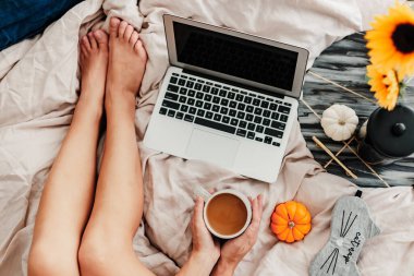 Kadın yatakta kahvenin tadını çıkarıyor. Sabah kahvesi içip kitap okuyordum. Ayçiçeği aranjmanı. Yatak odası titreşimi. Sonbahar sezonu. Evimde gibi hissediyorum. Küçük şeylerden zevk alıyorum. Sonbahar renkleri ve havası.