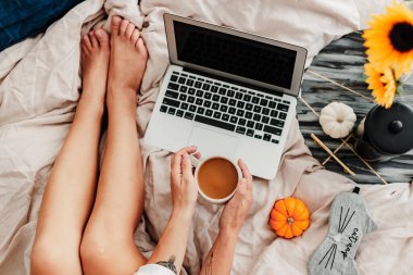 Kadın yatakta kahvenin tadını çıkarıyor. Sabah kahvesi içip kitap okuyordum. Ayçiçeği aranjmanı. Yatak odası titreşimi. Sonbahar sezonu. Evimde gibi hissediyorum. Küçük şeylerden zevk alıyorum. Sonbahar renkleri ve havası.