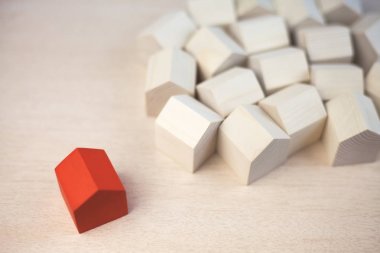 Birçok ahşap evin yakınında tek kırmızı ahşap ev. Kırmızı ahşap ev kalabalığın arasından ayakta