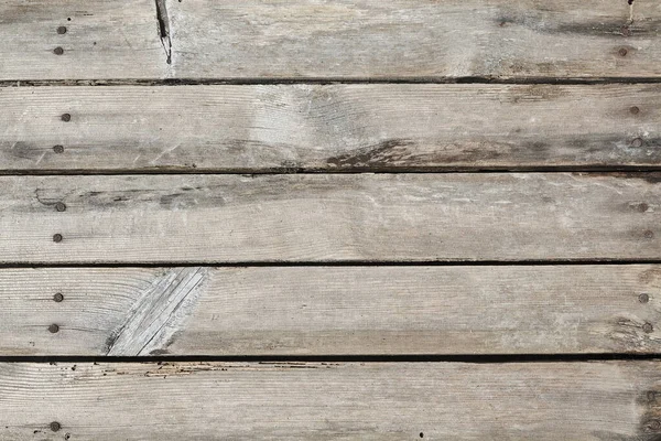 Piso de madeira feito de placas antigas com nós e rachaduras com unhas enferrujadas — Fotografia de Stock