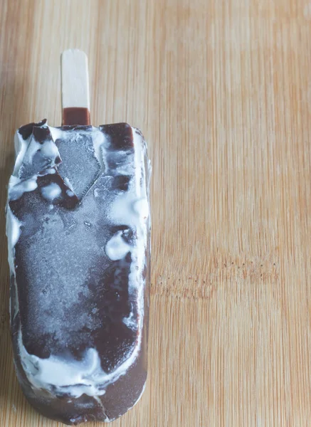 Tahta üstünde çatlak çikolata olan buzlu şeker..