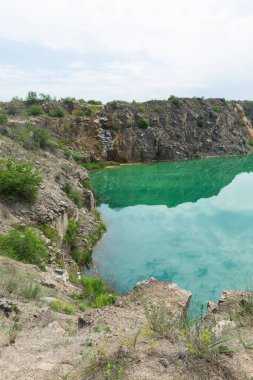 Gündüz vakti kayaların yansımasıyla pürüzsüz yeşil göl. 
