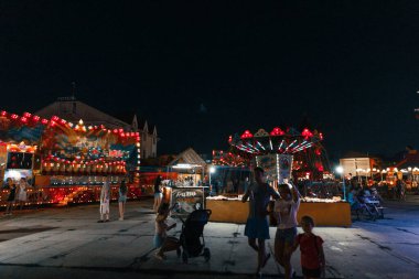 İnsanlar eğlence parkında akşam eğleniyor.