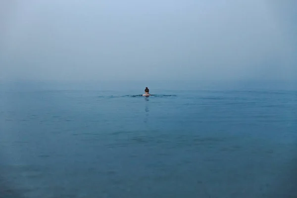 Young woman swimming in cold water.