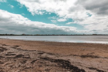 Nehir kenarındaki çamurlu yolda dramatik bir gökyüzü