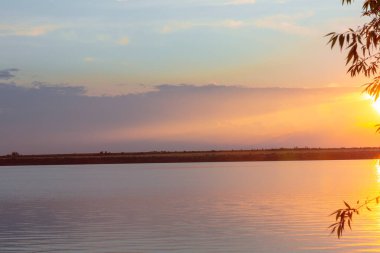 Nehrin üzerinde renkli günbatımı, gökyüzü yansıması