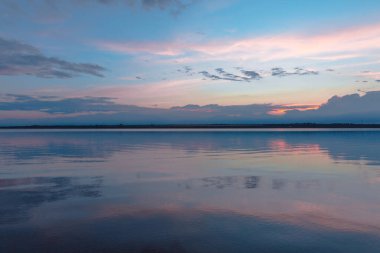Nehrin üzerinde renkli günbatımı, gökyüzü yansıması