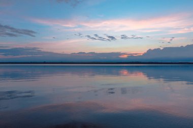 Nehrin üzerinde renkli günbatımı, gökyüzü yansıması