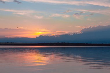 Nehrin üzerinde renkli günbatımı, gökyüzü yansıması