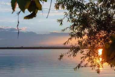 Nehrin üzerinde renkli günbatımı, gökyüzü yansıması
