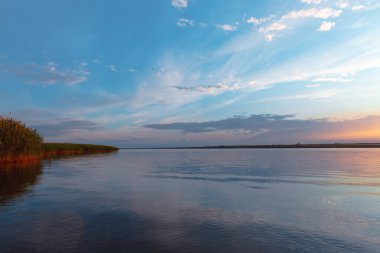 Nehrin üzerinde renkli günbatımı, gökyüzü yansıması
