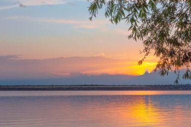Nehrin üzerinde renkli günbatımı, gökyüzü yansıması