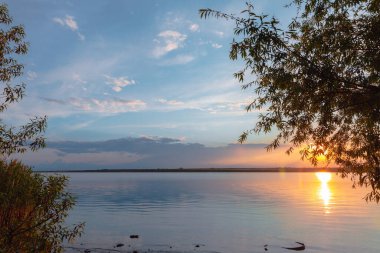 Nehrin üzerinde renkli günbatımı, gökyüzü yansıması