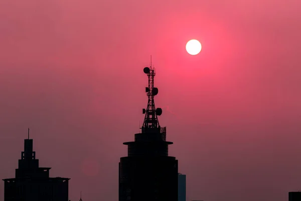 Um grande edifício com um pôr do sol no fundo — Fotografia de Stock