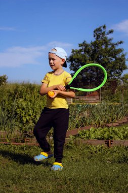 Summer, sarı tişörtlü bir çocuk harika tenis oynar.