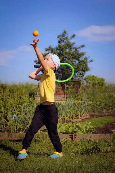 Summer, sarı tişörtlü bir çocuk harika tenis oynar.