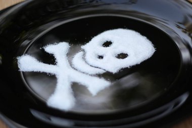 Şeker kafatası ve siyah bir plaka üzerinde çapraz kemikler