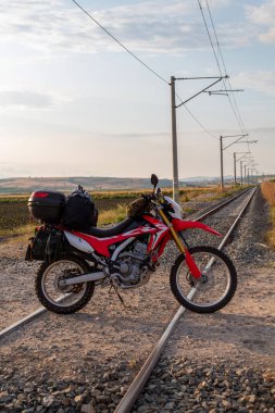 Motosiklet yüklendi, tren raylarında. 