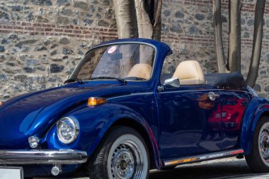 Lacivert klasik üstü açılabilir arabanın ön sol tarafı. 