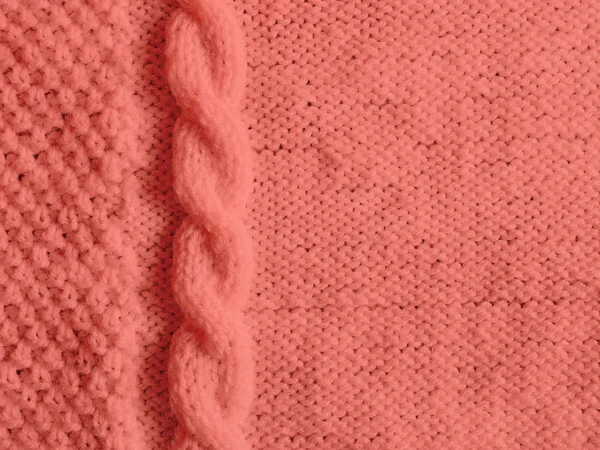 Texture of knitted woolen sweater dyed in Living Coral