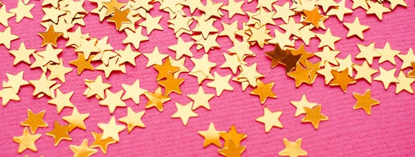 Golden stars glitter on pink background