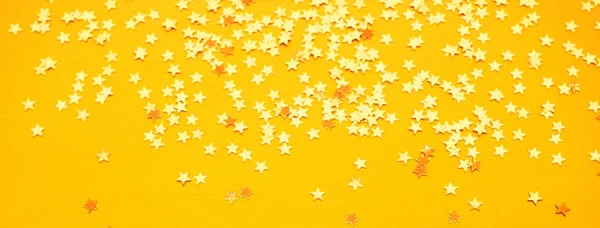 Étoiles dorées paillettes sur fond de papier jaune — Photo