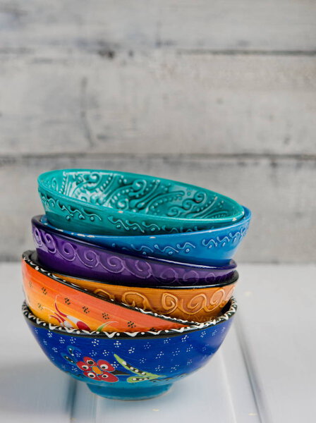 close up view of bright colorful bowls on wooden backdrop