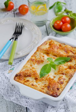 Lazanya bolognese ahşap masa üzerinde beyaz plaka