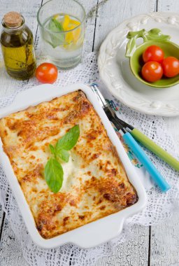 Lazanya bolognese ahşap masa üzerinde beyaz plaka